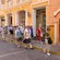 Tourists walk along a brick street next to old architecture